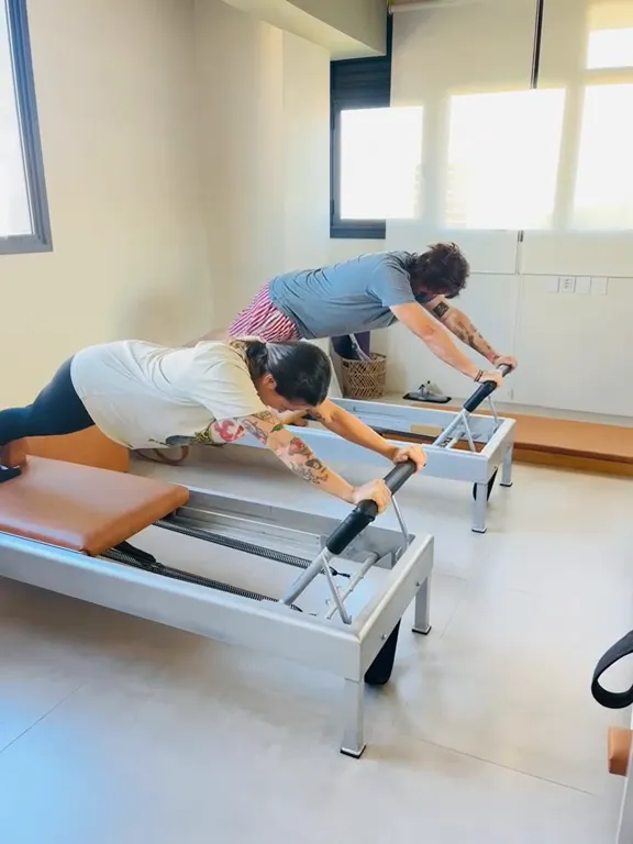 Duas alunas em aula de Pilates Clássico no Reformer, no estúdio Hera