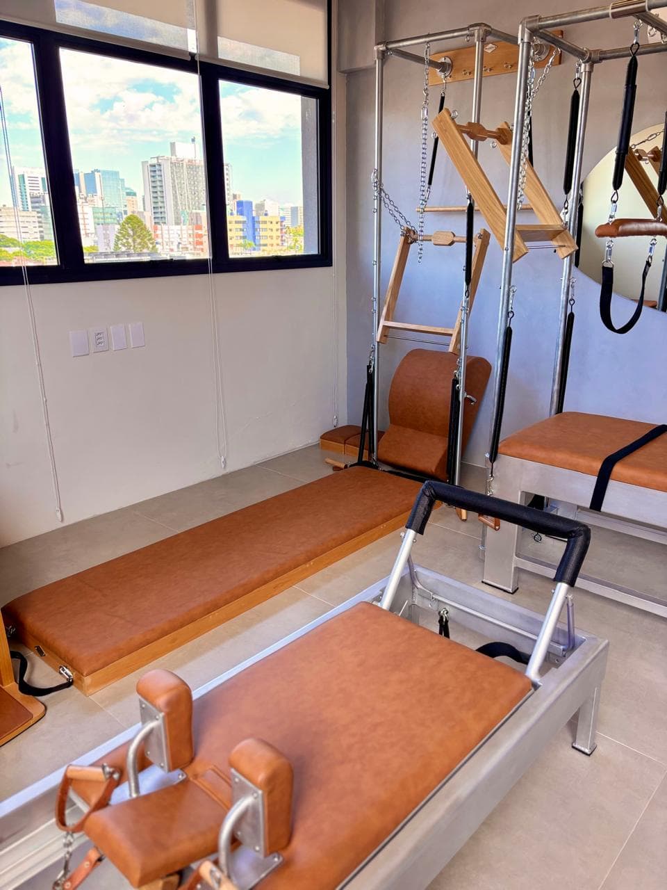 Ambiente acolhedor do Studio Hera Pilates. Sala principal do Studio Hera Pilates com aparelhos clássicos e iluminação natural, Menino Deus, Porto Alegre.